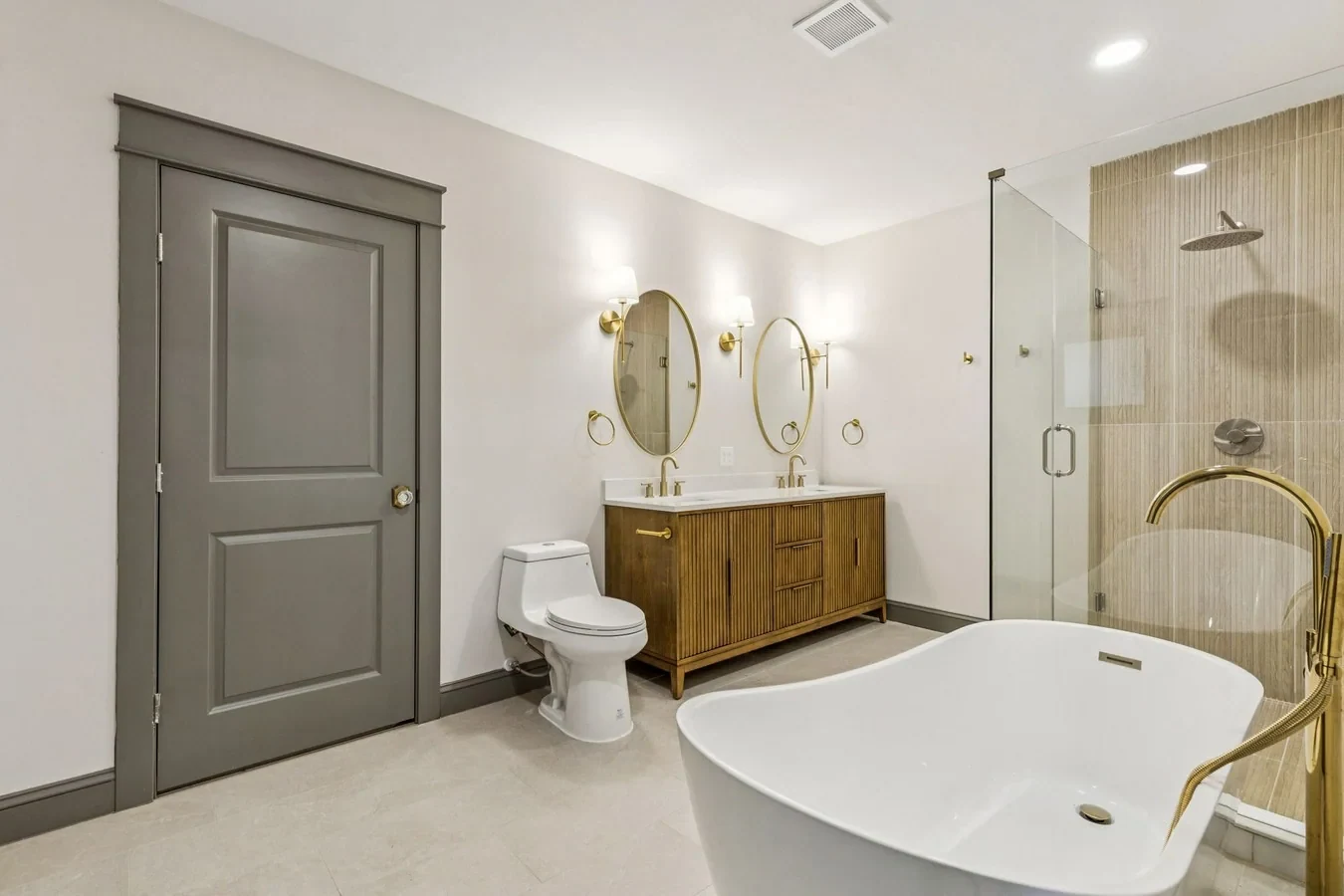 Primary bathroom addition with a freestanding tub, glass shower and wood double vanity in Bishop Arts, Dallas, Texas.